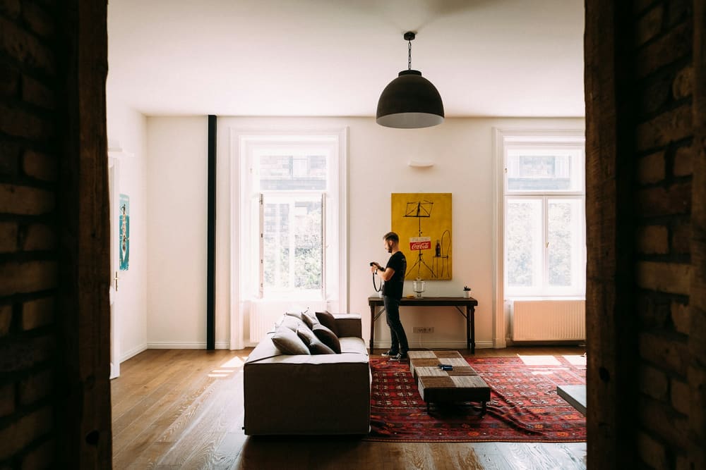 Une personne, téléphone en main, visite un appartement vide